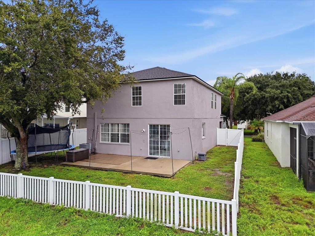 A two-story house with a concrete patio, a trampoline, and a white vinyl fence — 10908 SUBTLE TRAIL DRIVE, RIVERVIEW, FL