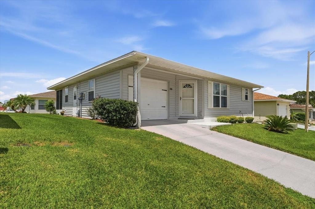 A light gray, single-story house with a white garage door and a concrete driveway — 1837 PRAIRIE DUNES CIRCLE S, LAKELAND, FL