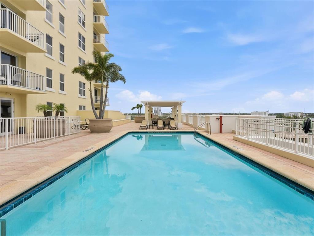 A swimming pool on a terrace next to a multi-story building with balconies — 628 CLEVELAND STREET UNIT 1507, CLEARWATER, FL