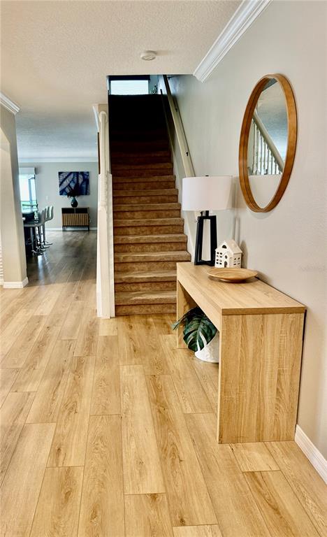 An entryway features a wooden console table, a round mirror, and carpeted stairs — 644 SAVANNAH PRESERVE LOOP, DAVENPORT, FL