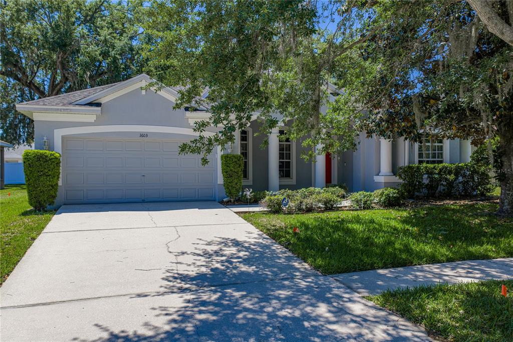 A single-story house with a gray exterior, a two-car garage, and a concrete driveway — 1603 GRAND HERITAGE BOULEVARD, VALRICO, FL