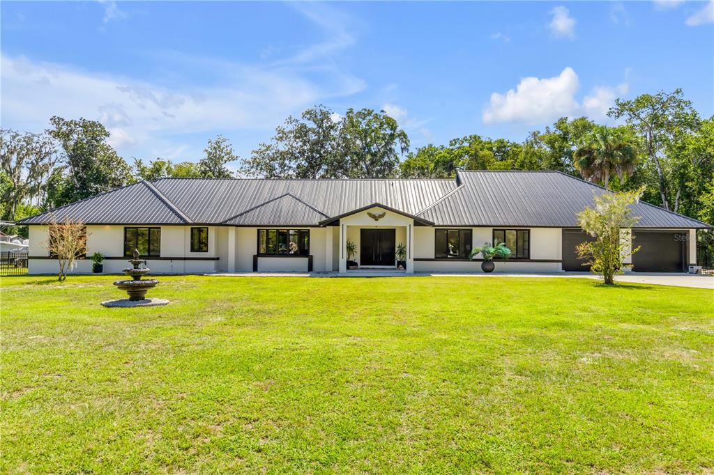 The exterior of a house features a covered entryway with double doors and an eagle sculpture — 6223 DONNA CIRCLE, PORT ORANGE, FL