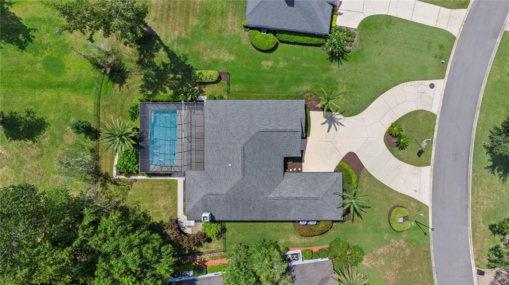 An aerial view shows a house with a screened-in pool, driveway, and surrounding lawn — 656 WYNDHAM COURT, ORANGE PARK, FL