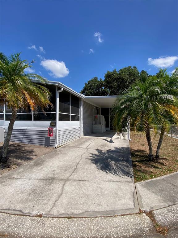 A mobile home exterior features a screened-in porch, gray metal skirting, and concrete steps — 8330 FANTASIA PARK WAY, RIVERVIEW, FL