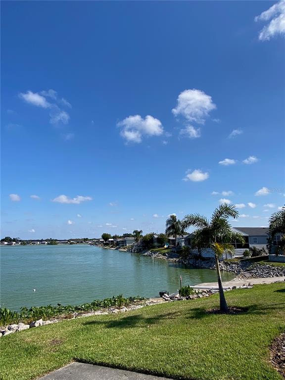 A single-story manufactured home features a screened-in front porch and a concrete driveway — 8330 FANTASIA PARK WAY, RIVERVIEW, FL