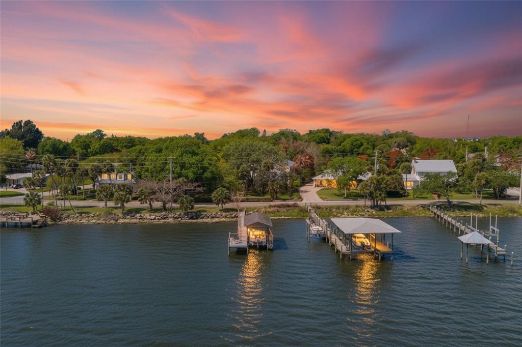 An aerial view shows a waterfront property with two boat docks at sunset — 409 ROCKLEDGE DRIVE, ROCKLEDGE, FL