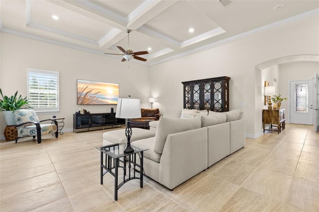 A living room features a large sectional sofa, a television, and tile flooring — 1528 FOREST GLEN COURT, PALM HARBOR, FL