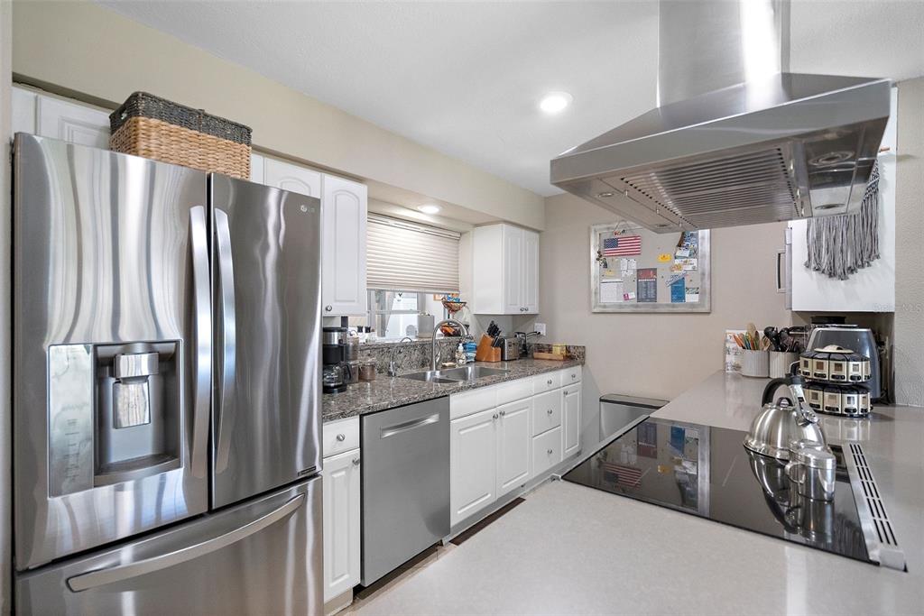 A kitchen features stainless steel appliances, white cabinets, and granite countertops — 101 MADONNA BOULEVARD, TIERRA VERDE, FL