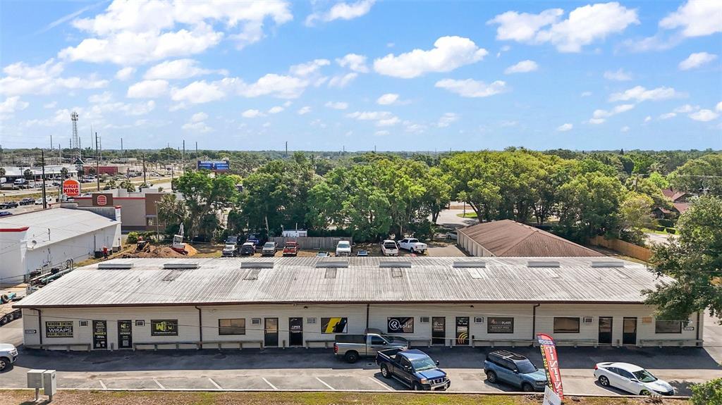 An aerial view shows a long, single-story commercial building with a metal roof and parking lot — 3101 KURT STREET, EUSTIS, FL