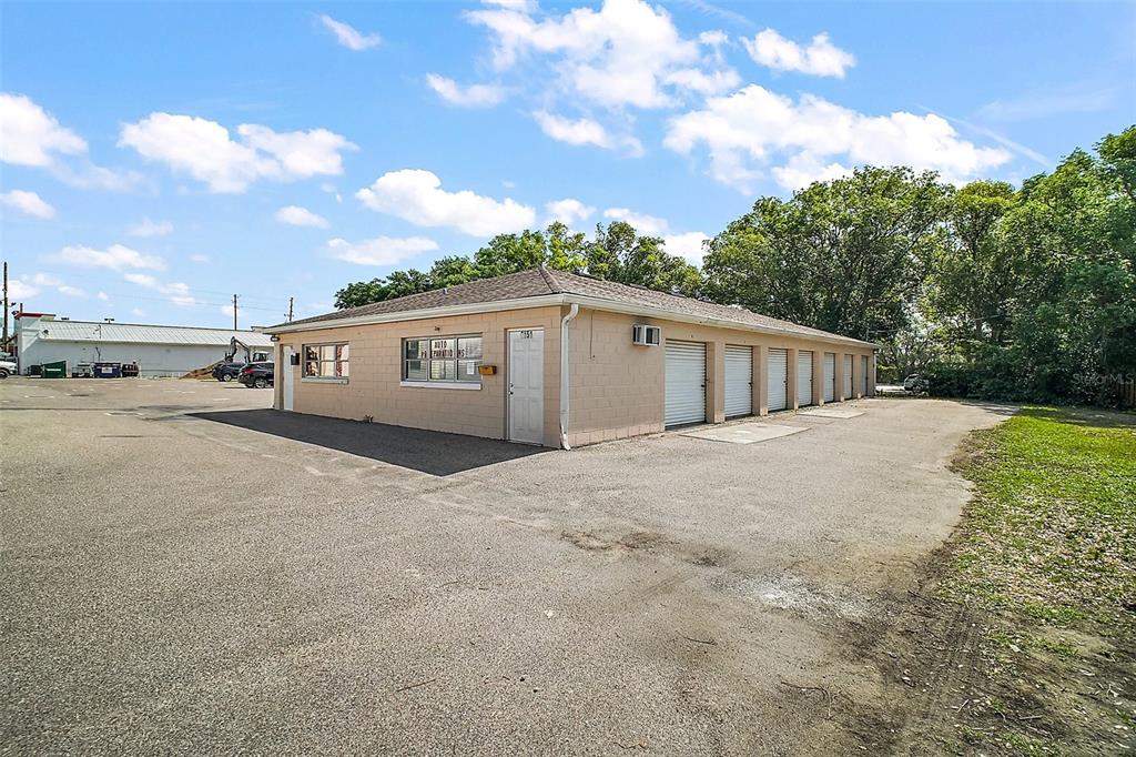 A single-story commercial building with a tan block exterior and multiple roll-up garage doors — 3101 KURT STREET, EUSTIS, FL