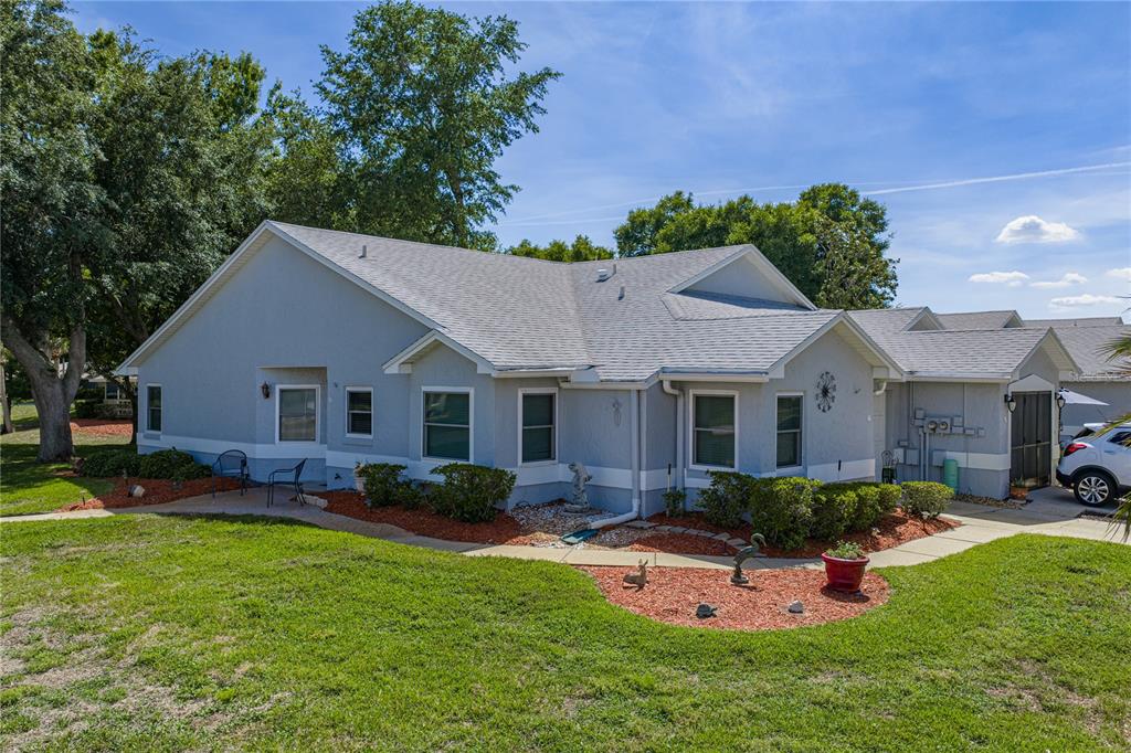 A single-story house with a gray stucco exterior, a shingled roof, and a grassy backyard — 6380 EGRET DRIVE UNIT 6, LAKELAND, FL