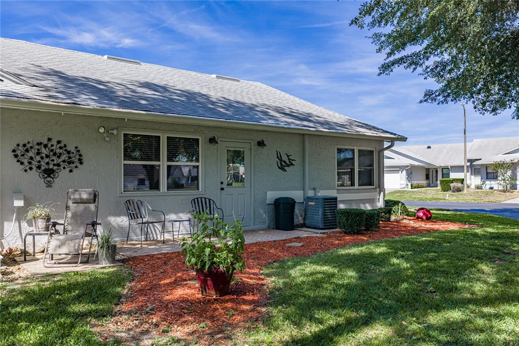A kitchen with wood cabinets, a small island, and a dining area with orange walls — 6380 EGRET DRIVE UNIT 6, LAKELAND, FL