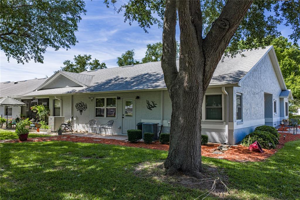 A kitchen and dining area with wood cabinets, a center island, and a round table — 6380 EGRET DRIVE UNIT 6, LAKELAND, FL