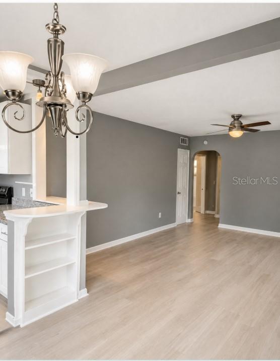 A dining area with a chandelier, built-in shelving, gray walls, and light wood flooring — 130 E DICIE AVENUE, EUSTIS, FL