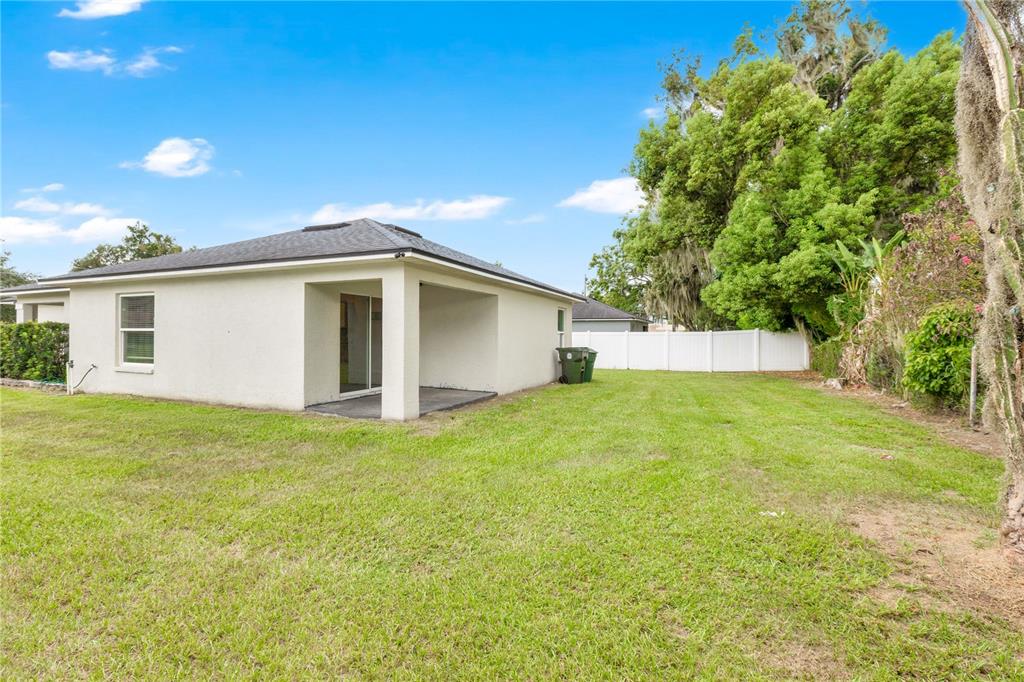 A kitchen features white cabinets, granite countertops, stainless steel appliances, and light wood-look flooring — 1185 FAIRVIEW AVENUE, BARTOW, FL