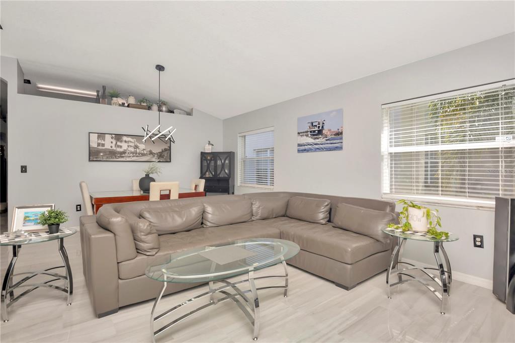 A living room features a gray sectional sofa, a glass coffee table, and dining furniture — 2239 ROANOKE SPRINGS DRIVE, RUSKIN, FL