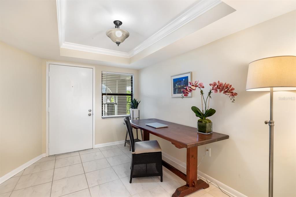 A home office features a wooden desk, a black chair, tile flooring, and a ceiling light — 950 PALM AVENUE UNIT 304, BOCA GRANDE, FL