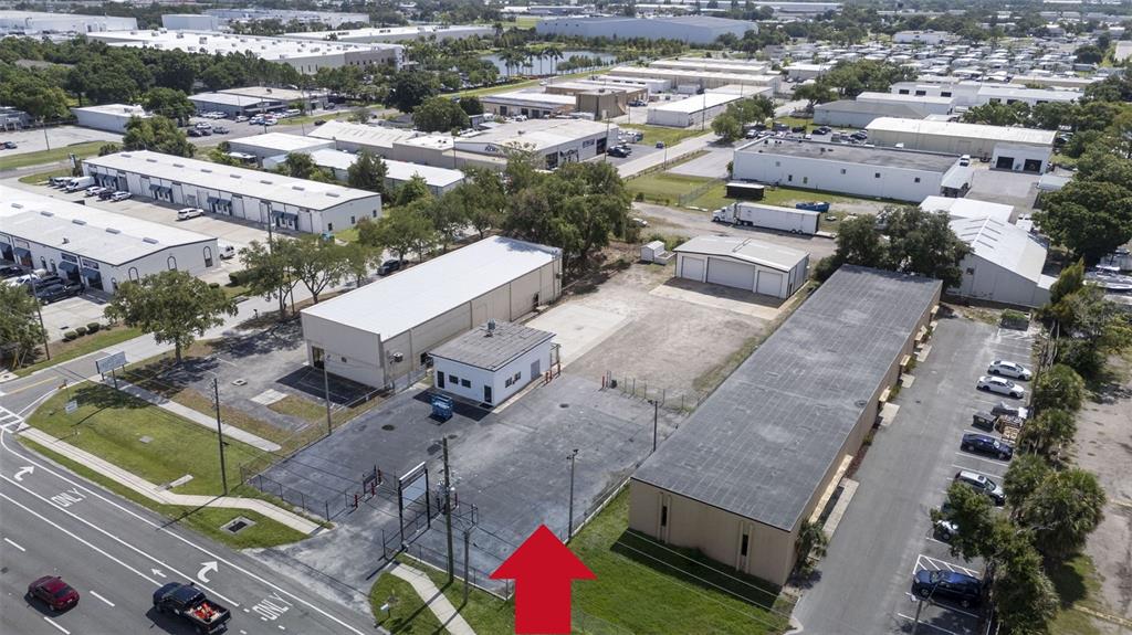 An aerial view shows a commercial property with a fenced parking lot and several buildings — 12433 66TH STREET, LARGO, FL