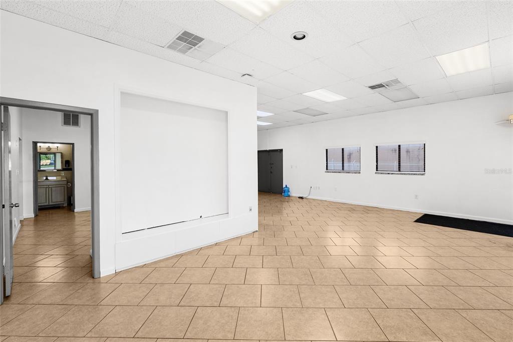 An empty commercial space with beige tile flooring, white walls, and a recessed wall niche — 12433 66TH STREET, LARGO, FL