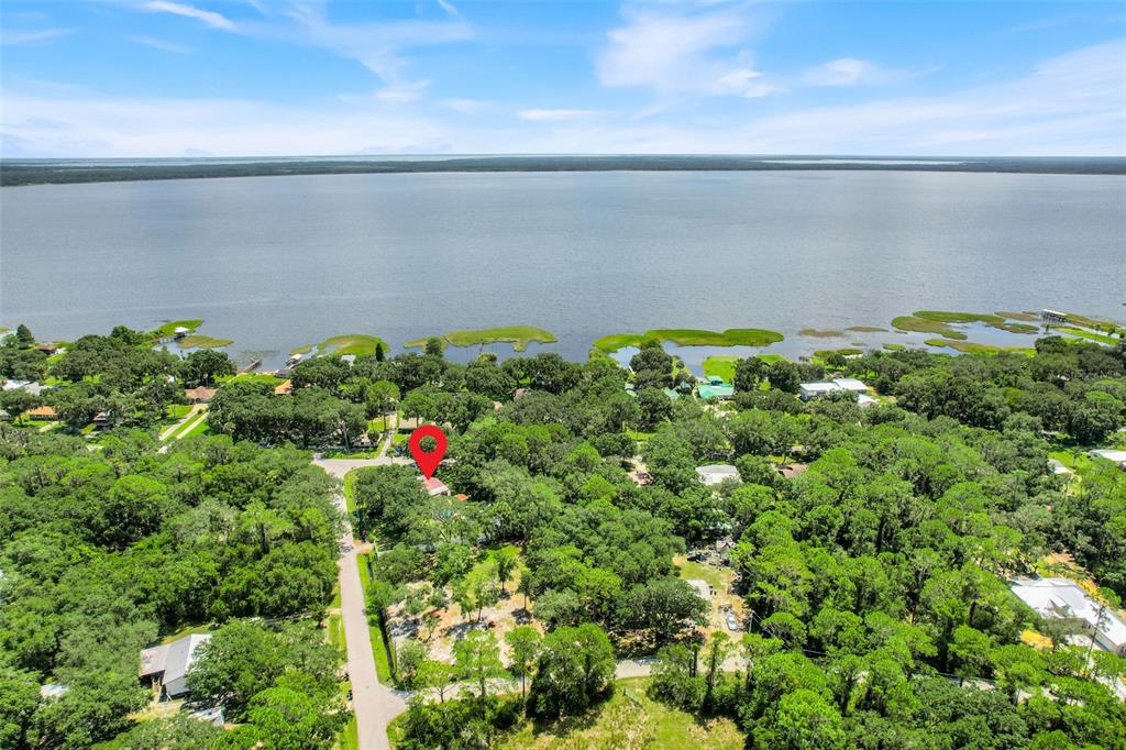 An aerial view shows a house marked with a red pin surrounded by dense trees — 11031 W BEACH PARKWAY, LAKE WALES, FL
