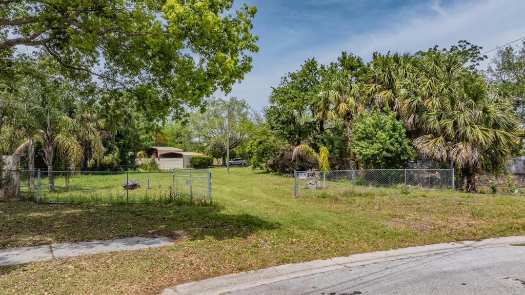 A fenced, grassy vacant lot features scattered trees, palm trees, and a small shed — 0 VILLA DRIVE, HUDSON, FL