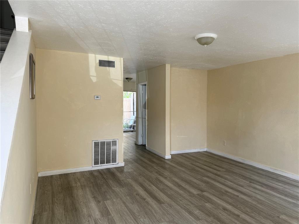 A living room features light wood-look flooring, a sectional sofa, and a desk workspace — 4004 BARWOOD DRIVE UNIT 3804, ORLANDO, FL