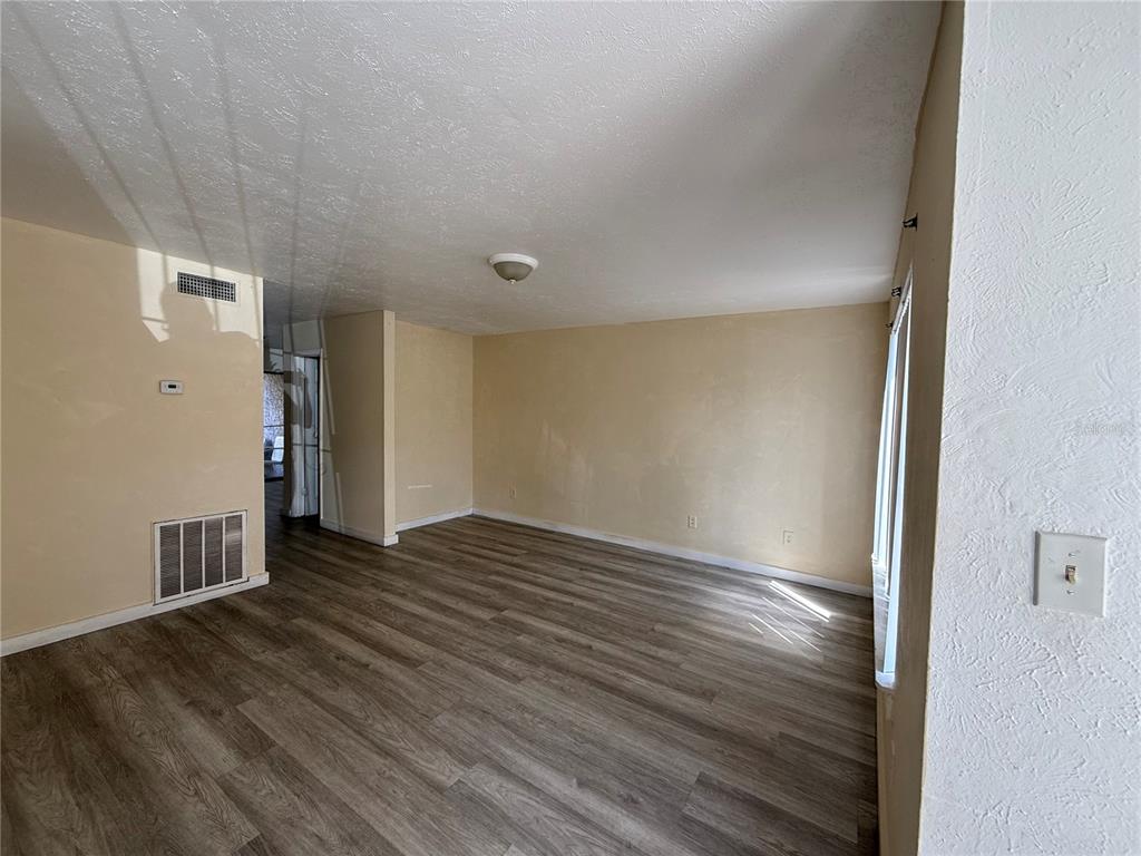 A dining area features a wooden bar, sliding glass doors, and a table with chairs — 4004 BARWOOD DRIVE UNIT 3804, ORLANDO, FL