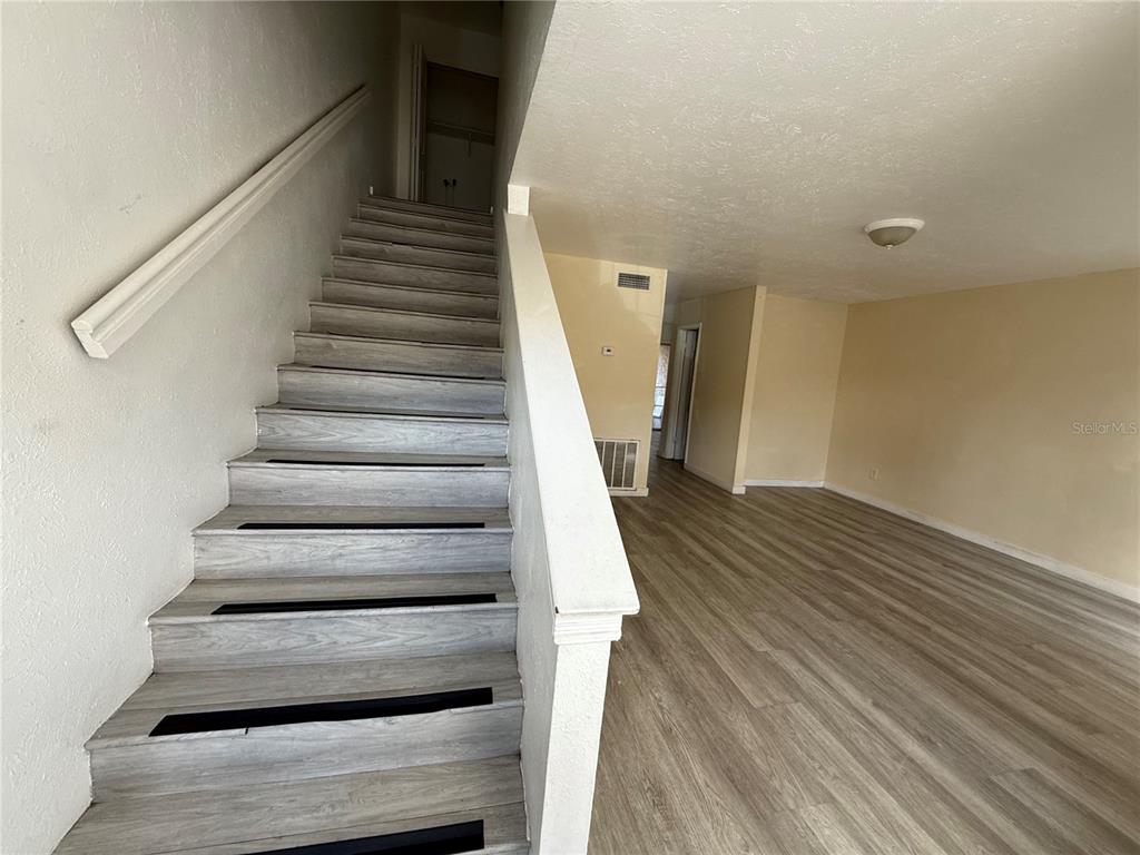 A dining area features a wooden table, chairs, sliding glass doors, and light wood-look flooring — 4004 BARWOOD DRIVE UNIT 3804, ORLANDO, FL