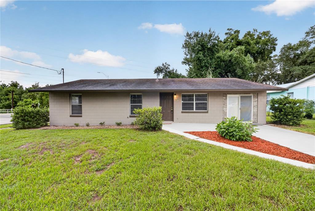 A single-story house with a gray block exterior, a brown roof, and a front lawn — 507 S OHIO AVE, GROVELAND, FL