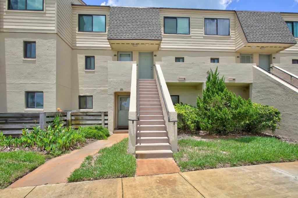 An exterior view of a multi-story townhouse with a central staircase leading to an entrance — 8550 A1A S UNIT 14250, ST AUGUSTINE, FL