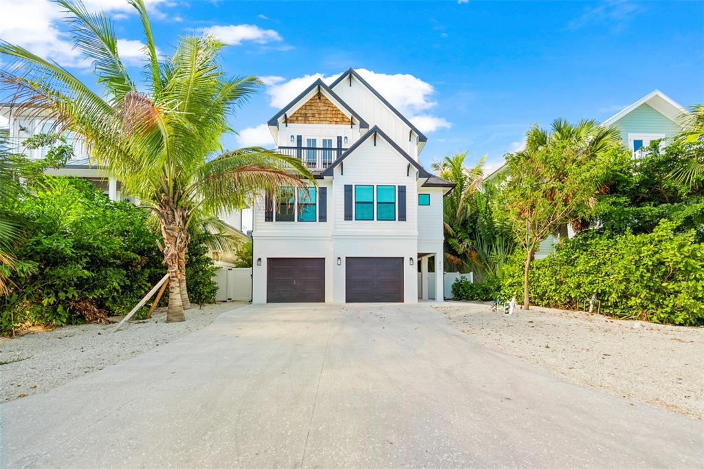 A two-story white house with two garage doors and a palm tree in the front — 211 GRANT DRIVE, SARASOTA, FL