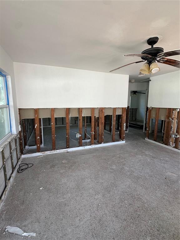 An interior room under renovation with exposed wall studs and a concrete floor — 13434 1ST ST E, MADEIRA BEACH, FL