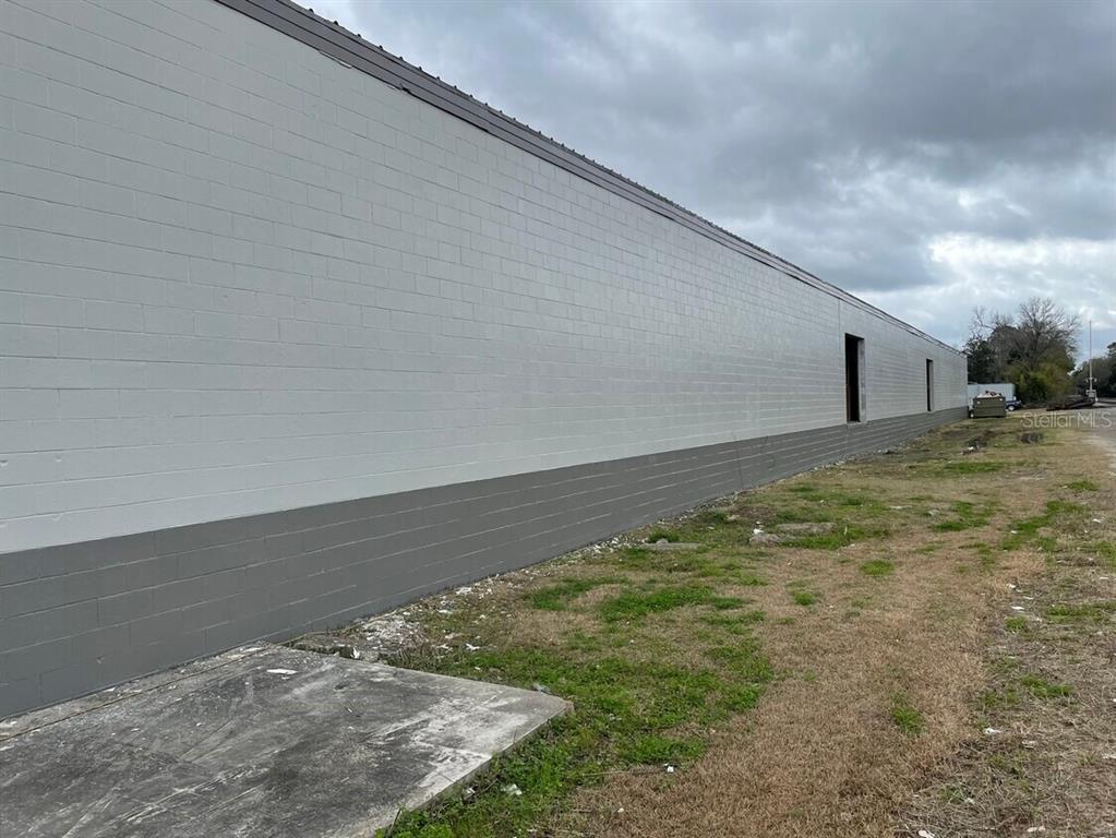 A long, exterior concrete block wall of a building with gray and white paint — 385 E WASHINGTON STREET, STARKE, FL