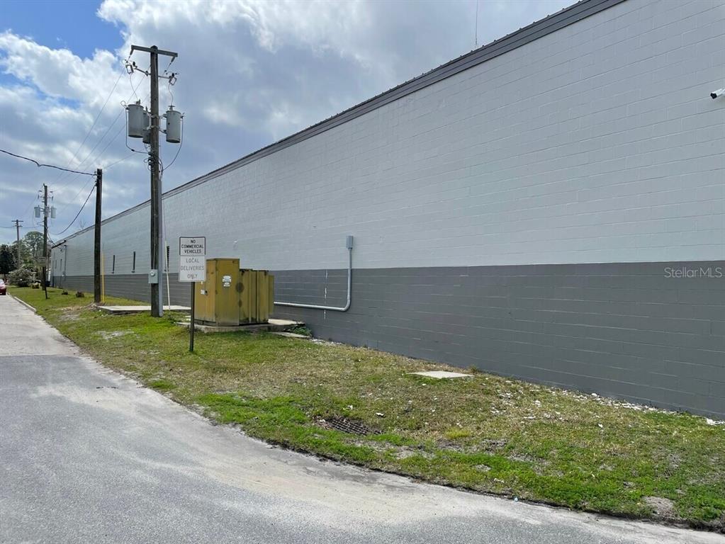 A long, gray and white concrete block building sits beside a paved road and utility pole — 385 E WASHINGTON STREET, STARKE, FL