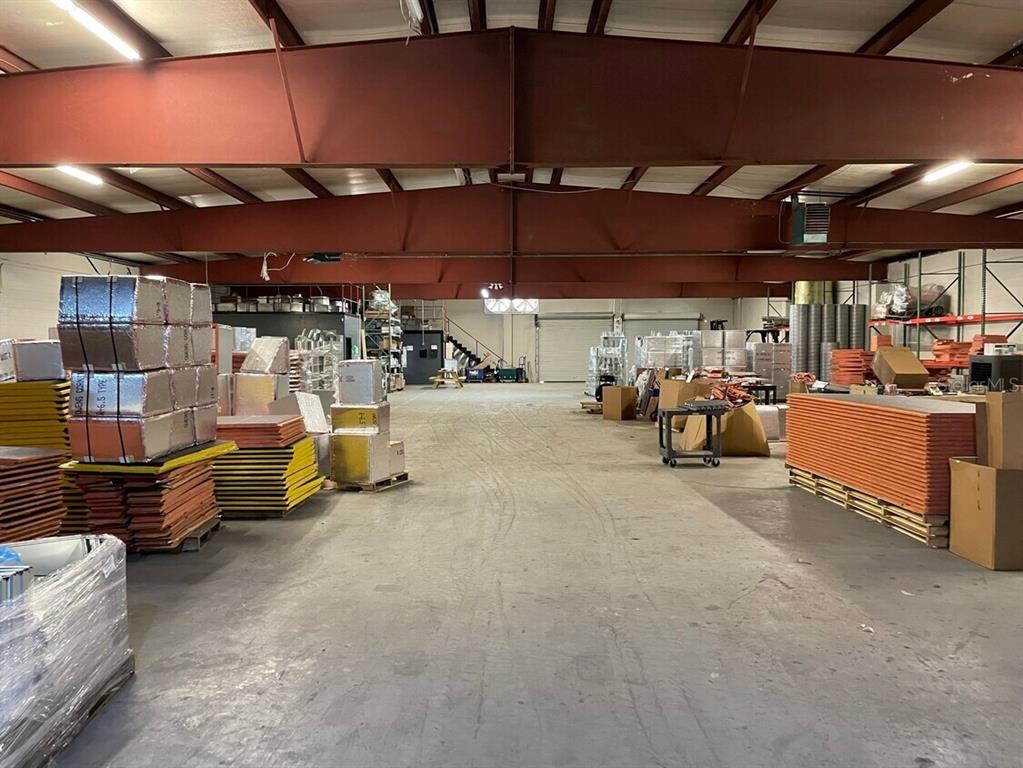 This is a large, open warehouse space with concrete floors and exposed steel ceiling beams — 385 E WASHINGTON STREET, STARKE, FL