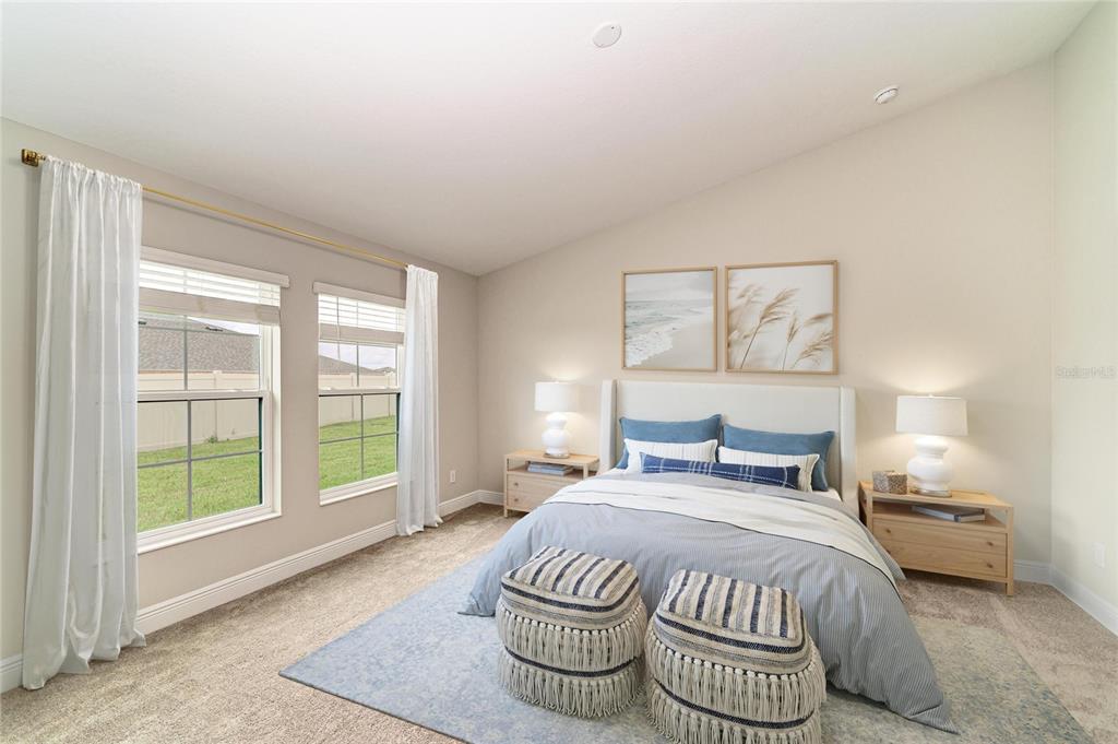 A bedroom features a bed with blue bedding, two nightstands, and two windows with curtains — 12365 OAK  HILL WAY, PARRISH, FL