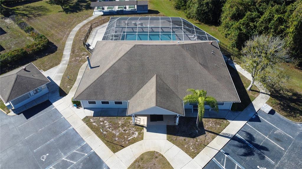 An aerial view shows a community clubhouse with a screened pool and adjacent parking lots — FOREST GLENN DRIVE, SPRING HILL, FL