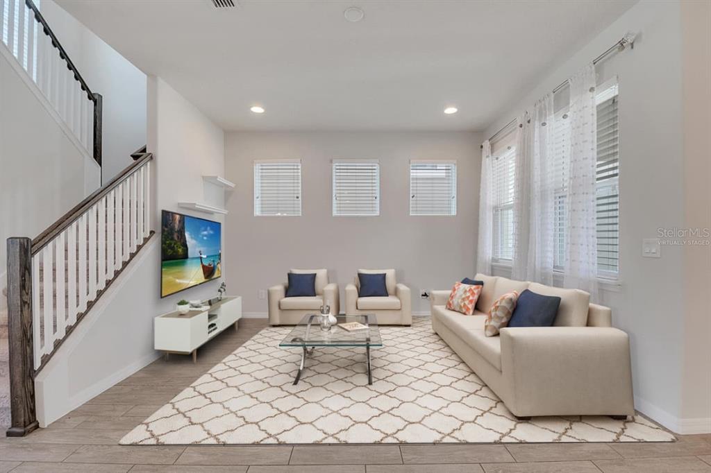 A home office features a white desk, three black chairs, and abstract wall art — 8048 SCAGEL STREET, ORLANDO, FL
