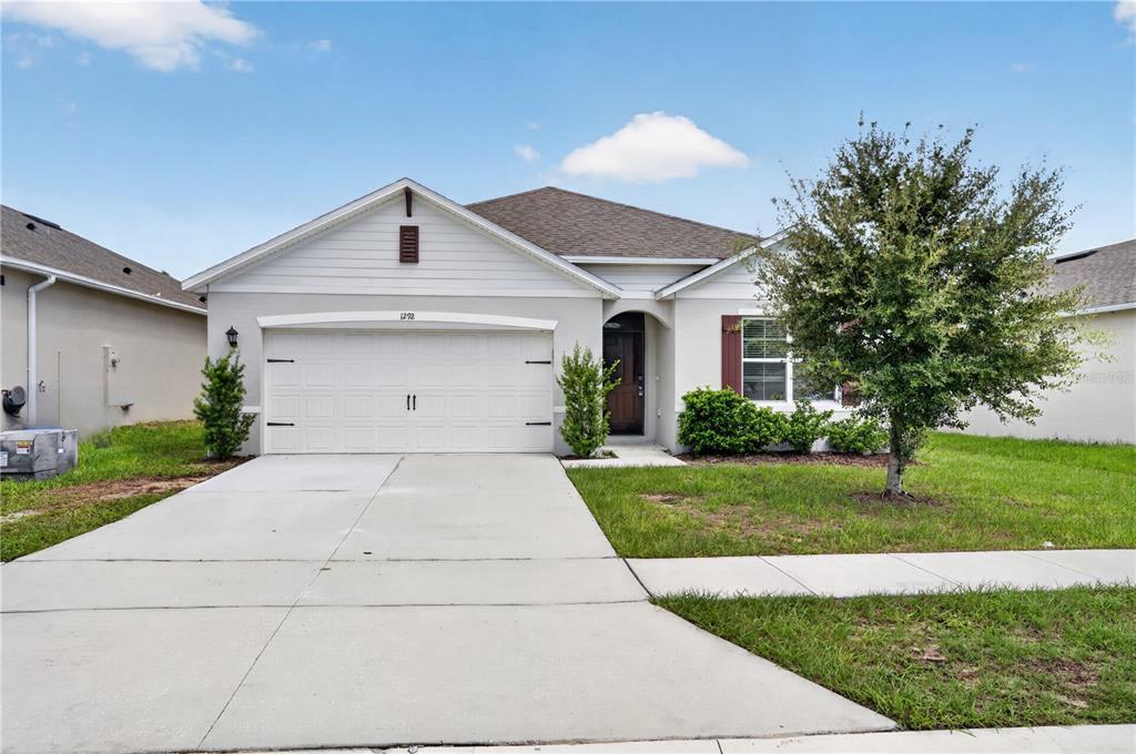 An empty bedroom features beige walls, brown carpeting, and a single window with blinds — 1292 SUGARWOOD STREET, DAVENPORT, FL
