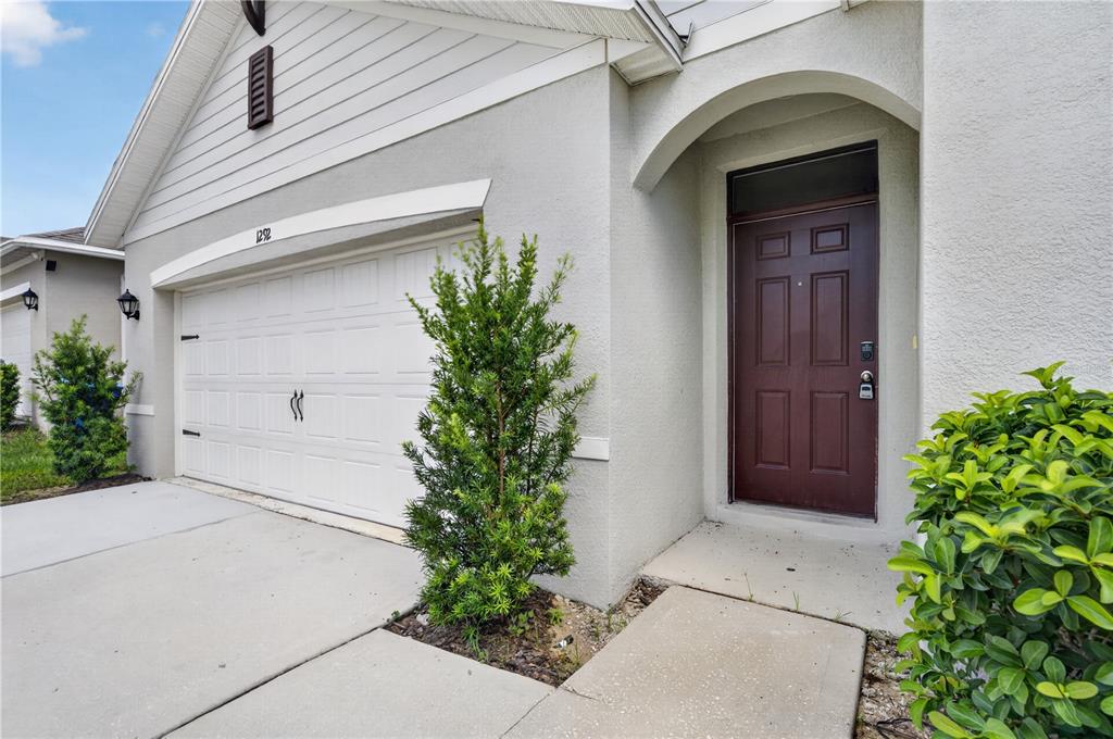 A kitchen with white cabinets, granite countertops, a center island, and tile flooring — 1292 SUGARWOOD STREET, DAVENPORT, FL