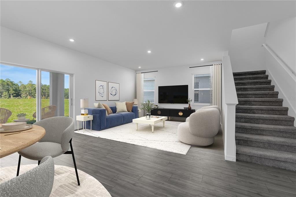 This is a digital rendering of a living room with gray flooring, stairs, and patio access — 12837 TROVITA DRIVE, GRAND ISLAND, FL