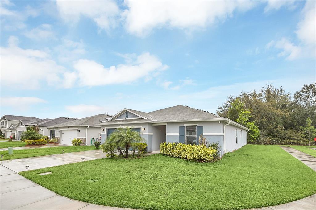 A single-story suburban house with a gray exterior, a two-car garage, and a front lawn — 1877 RIVER CREST AVENUE, ST CLOUD, FL