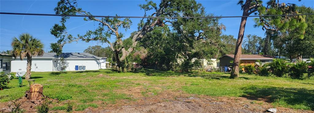 A vacant, grassy residential lot features several mature trees and neighboring houses in the background — EDMONDSON ROAD, NOKOMIS, FL
