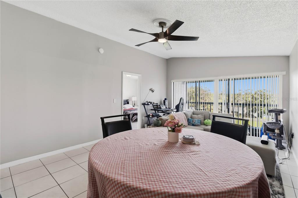 A dining area with a round table, tile floors, and a view into a living room — 1064 LOTUS PARKWAY UNIT 941, ALTAMONTE SPRINGS, FL