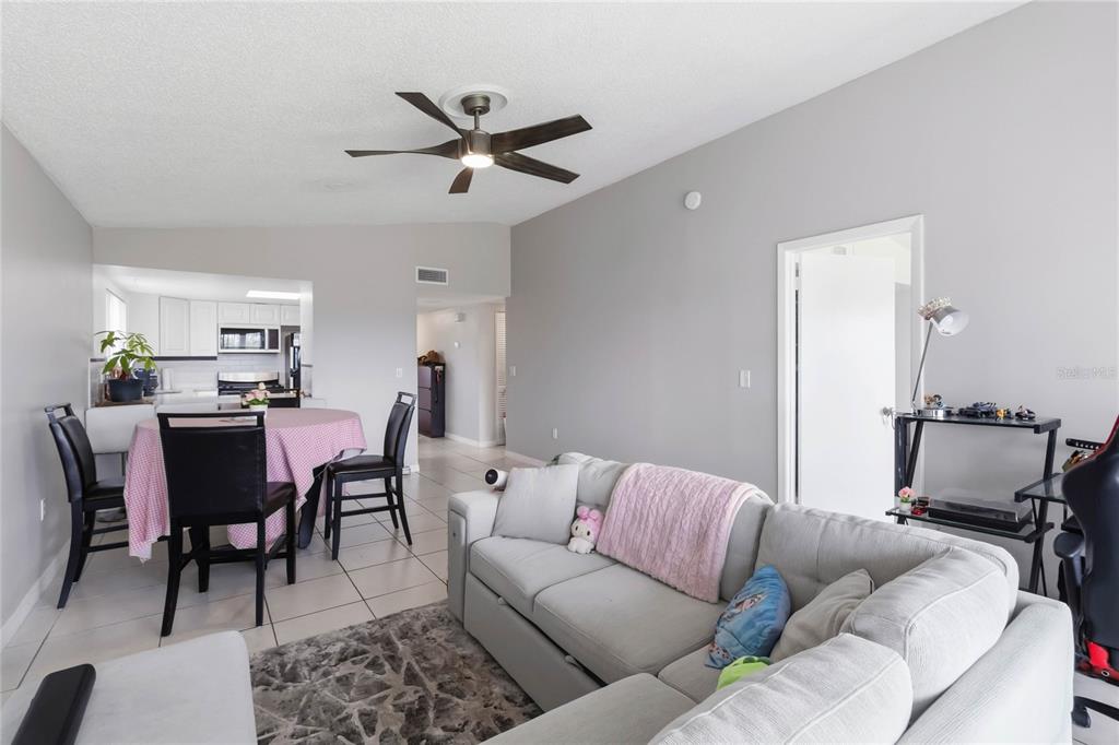 A living room with a sectional sofa, dining area, and kitchen in an open floor plan — 1064 LOTUS PARKWAY UNIT 941, ALTAMONTE SPRINGS, FL