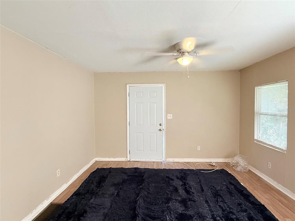 A room with wood-look flooring, two windows, a ceiling fan, and a white refrigerator — 986 22ND AVENUE S UNIT 3, ST PETERSBURG, FL