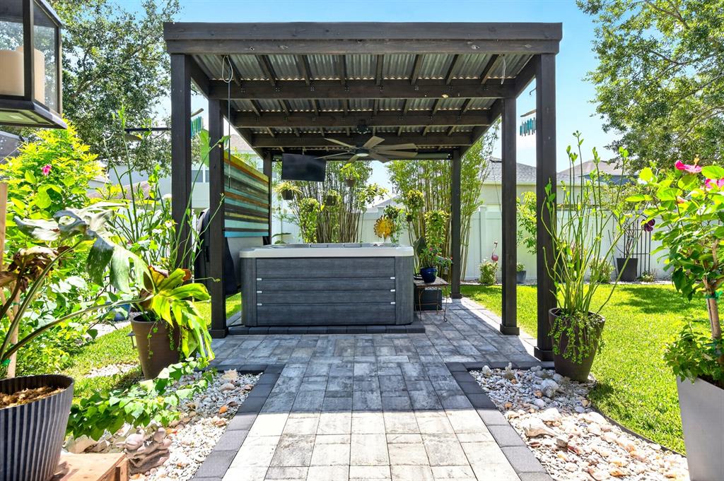 A hot tub sits under a wooden pergola on a paved patio in a backyard — 1135 TOLUKE POINT, ORLANDO, FL