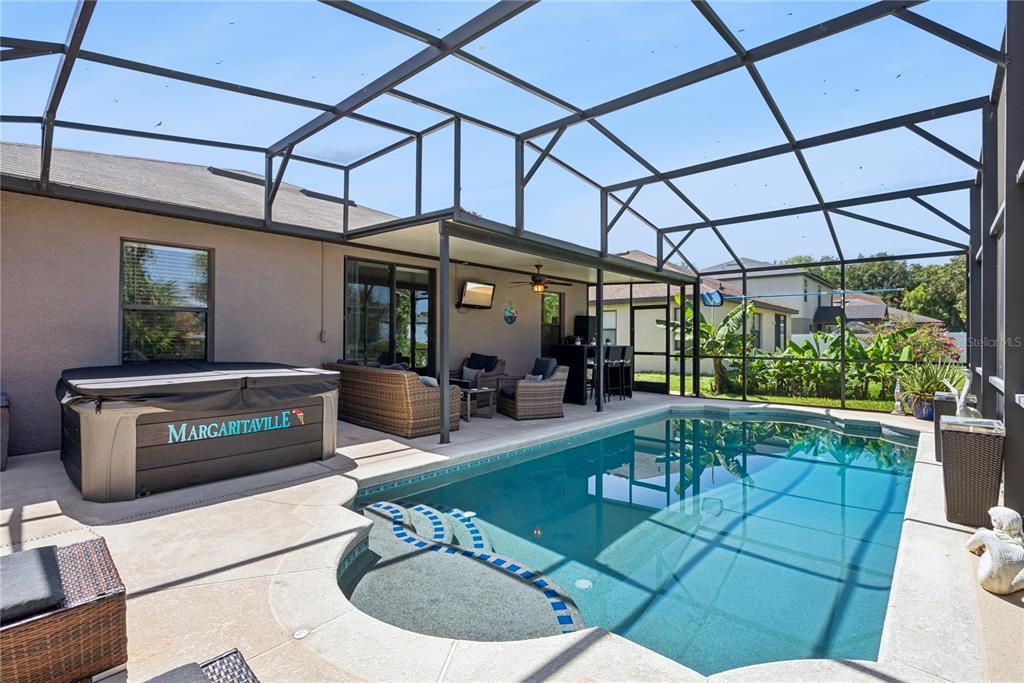 A screened-in patio features a swimming pool, a hot tub, and outdoor seating furniture — 2440 VINEYARD CIRCLE, SANFORD, FL