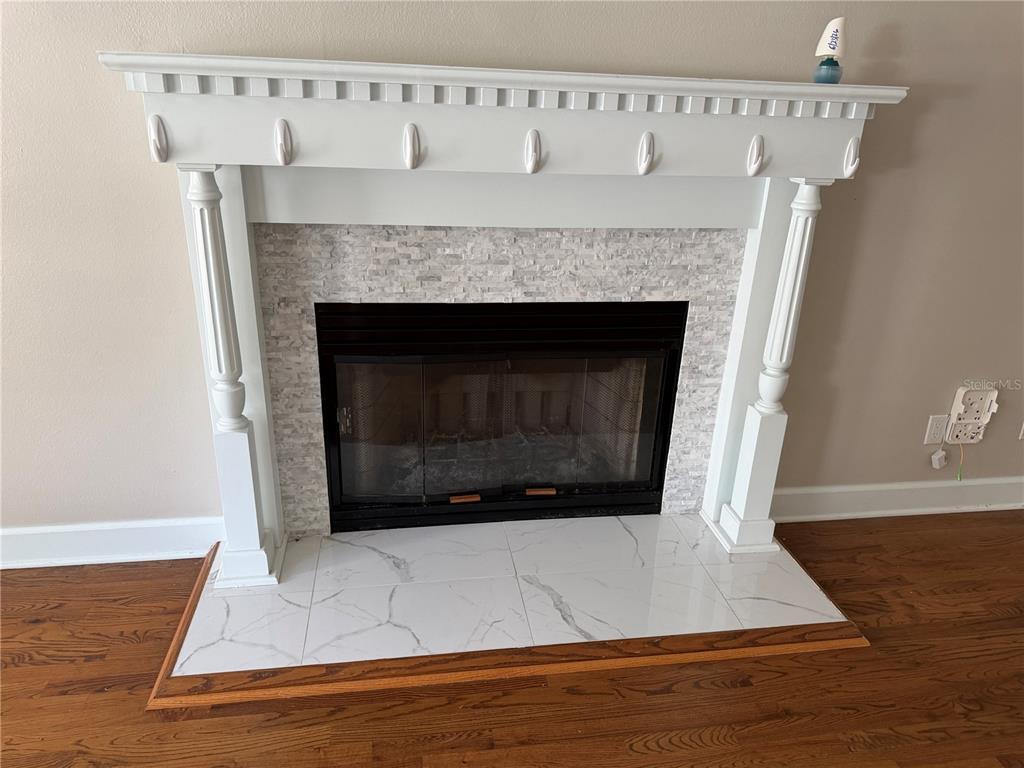 A living room features hardwood floors, a white fireplace mantel, and a ceiling fan — 916 HILLCREST COURT, TALLAHASSEE, FL