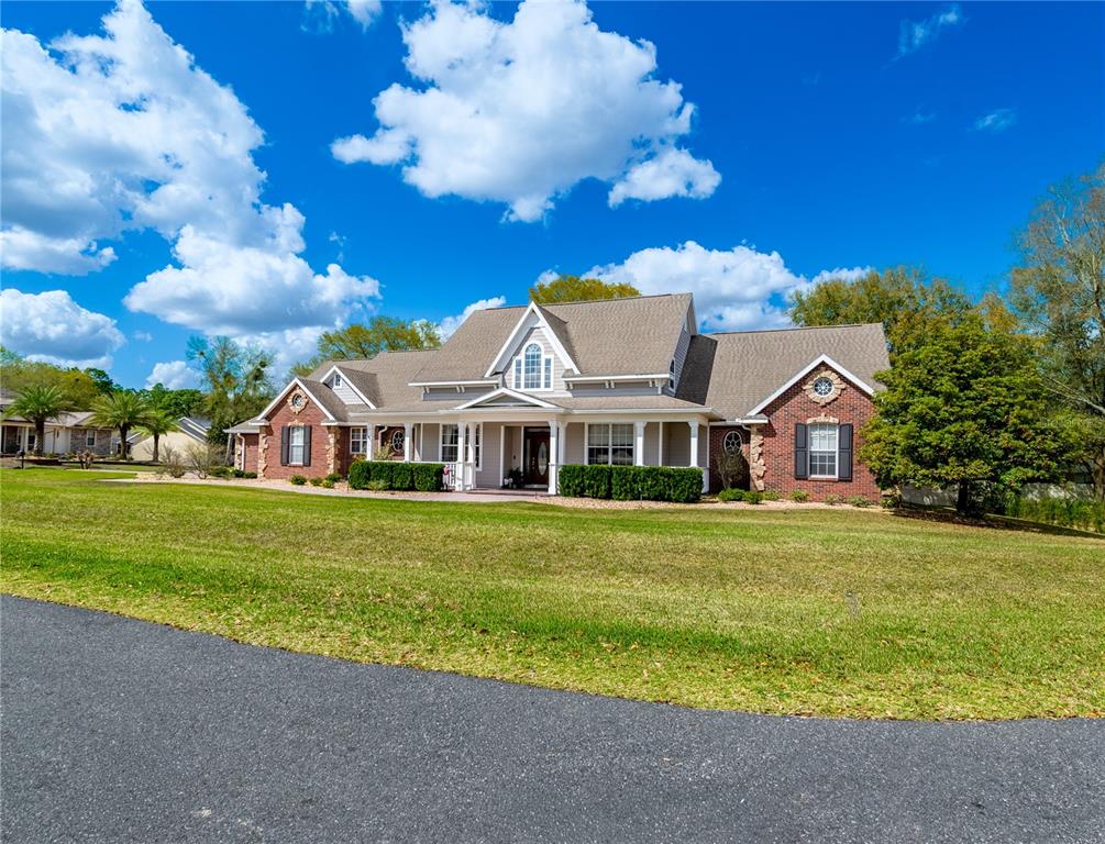 A large, single-story house with a brick and siding exterior sits on a grassy lawn — 5795 SW 43RD PLACE, OCALA, FL